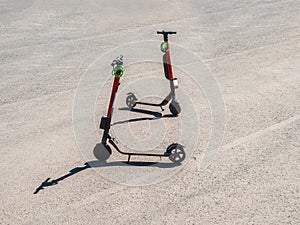 Two parked scooters in the summer city. Modern youth mode of transport