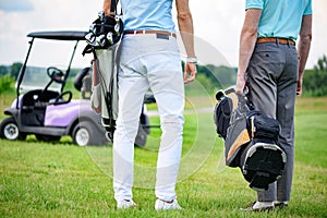 Two partners of game standing on golf course