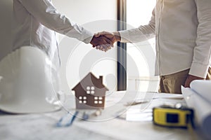 Two partnership engineering man with construction worker greeting shaking hand a foreman at renovating apartment