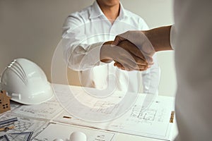 Two partnership engineering man with construction worker greeting shaking hand a foreman at renovating apartment