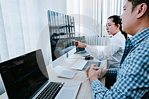 Two partnerships developing programming and coding technologies working on laptop and analyzing together photo