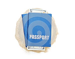 Two passports with money on the heap of sand. Isolated on white. Top view. Travel concept