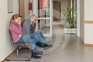 two patients sitting in the waiting room of a doctor's office