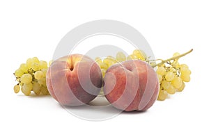 Two peaches and grapes branch on white