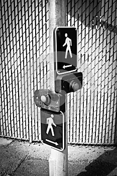 Two pedestrian crossing buttons in the street in black and white photo