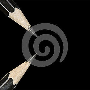 Two pencils macro are isolated on a black background