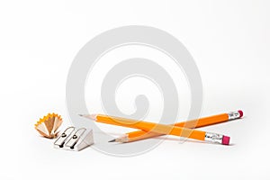 Two Pencils with pencil sharpener and sharpening shavings on white background. stationery.