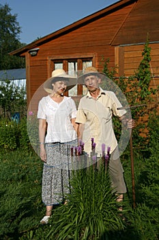 Two pensioners against a wooden house