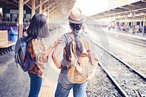 Two people Asian woman tourist standing carrying a backpack. Wait for the train at Hua Lamphong Bangkok Thailand. During his