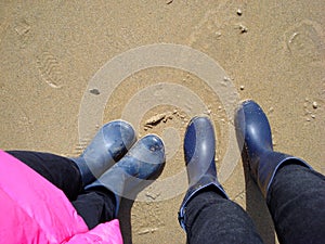 Two people in boots on the beach