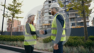 Two people colleagues in safety uniform helmets hardhat engineers managers man and woman female leader male worker