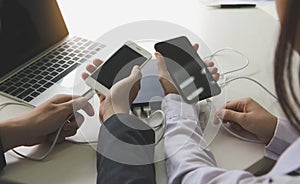 Two people connecting the mobile to a power bank.Technology device charge sharing concept