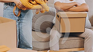 .Two people couple interracial family ameste in living room in new apartment open cardboard boxes receive parcels with orders from