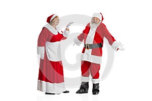Two people, elder man and woman, Santa Claus and missis Claus in traditional New Year costume talking isolated on white