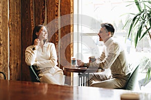 Two People Engaged in Casual Conversation at a Cozy Cafe During the Day