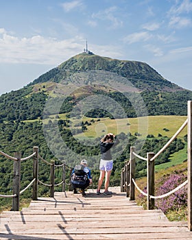 Two people getting ready to descend the Puy de Pariou stairs in summer.