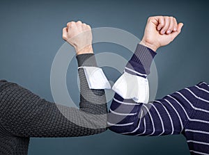 Two people greeting each other with elbows