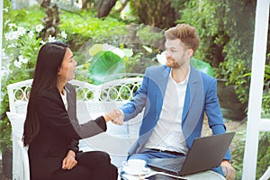 Two people happiness success business partner shaking hands in the office, businessman and businesswoman handshake successful