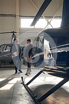 Two people having conversation in aircraft hangar