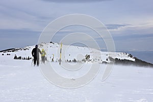 Two people hiking in the snow, severe winter weather high in Vitosha Mountain, Bulgaria