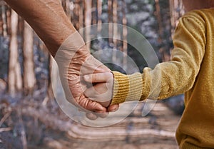 Two people hold hands, the older and younger generation of people, grandmother and granddaughter holding hands. Walk in