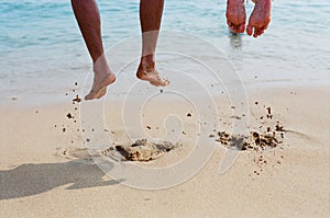 Two people are jumping on the beach