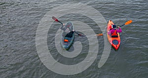 Two people in kayaks glide over Lake Ontario top view cinematic shot. Leisure on Lake Ontario with kayaks healthy