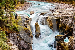 Two people looking at Sunwapta Falls in Jasper National Park