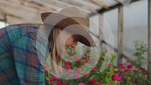 Two people a man and a woman with a tablet computer inspect flowers in a greenhouse on a rose plantation. Close - up of