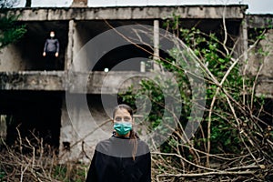 Two people in masks in a abandoned location.Abandoned city ruins. Divided by incurable infectious disease,catastrophe.Isolation.