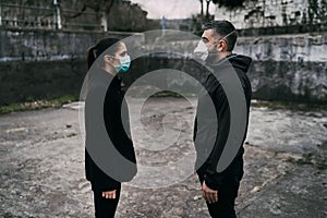 Two people in masks talking from distance.Couple being divided by incurable infectious disease.Infection control,isolation. photo