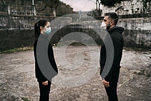 Two people in masks talking from distance.Couple being divided by incurable infectious disease.Infection control,isolation.Loved photo