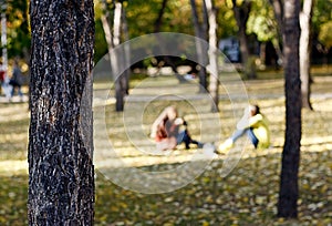 Two people in the park in autumn season with blur background