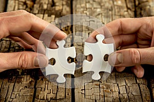 Two people putting two puzzle pieces together - concept image created by CNC machine