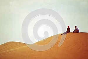 Two people resting on desertdune