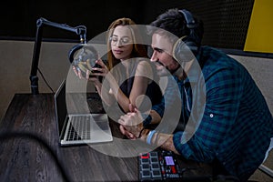 Two people sitting at the table and watching something on laptop