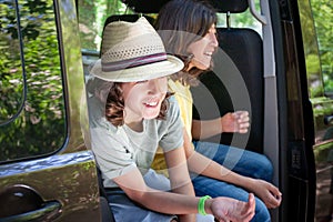 Two people are sitting in a van smiling