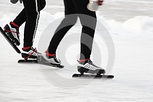 Two people skate on the ice.