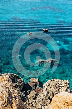 Two people snorkling in turquoise Mediterranean Sea,Malta.Aerial view of swimming people.Relax vacation concept.Crystal clear