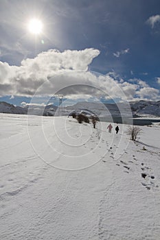 Two people in Snowy Landscape with Lake photo