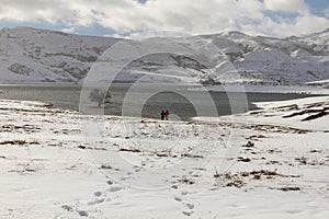 Two people in Snowy Landscape with Lake photo