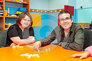 Two people with special needs distracted playing board games