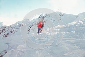 Two people stand on a mountain ski resort