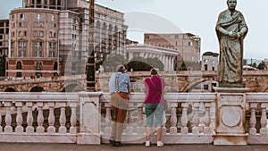 two people standing on a bridge near a statue of Saint Anthony: Skopje