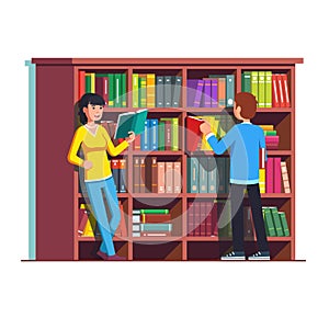 Two people standing in front of wooden bookcase