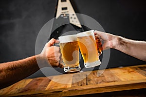 Two people toasting with mugs full of chopp.