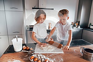 Two people together. Little boy and girl preparing Christmas cookies on the kitchen