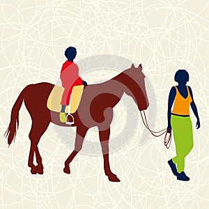 Two people walking and riding a horse.