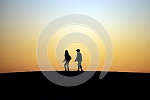 Two People Walking Together at Sunset