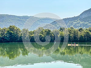 Two peoples kayaking on the coiselet lake, Jura